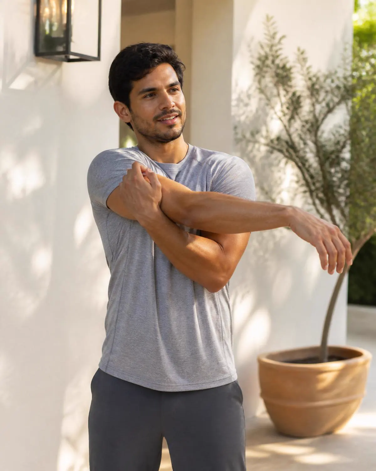 Active adult stretching on a sunlit patio after a morning workout