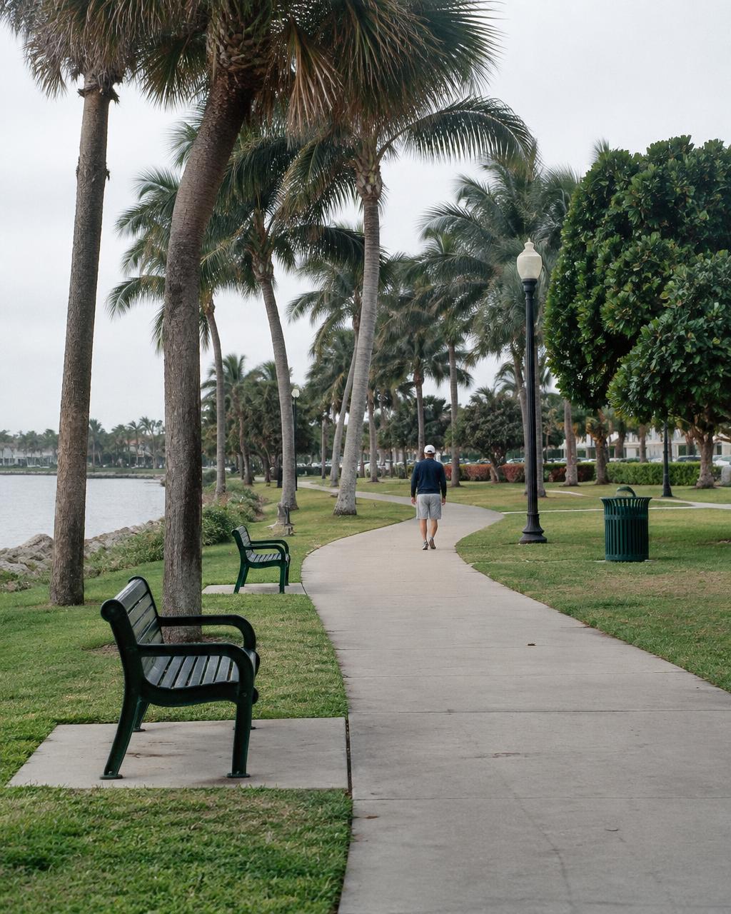 Adult walking outdoors near coastal palms in Palm Beach County